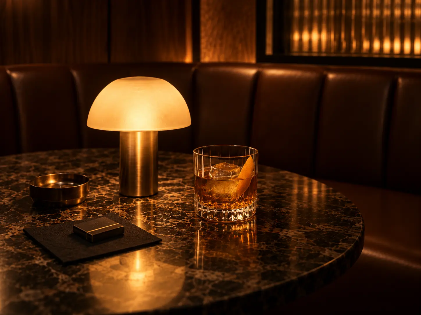 Whiskey and a brass lamp on a marble table at JADE